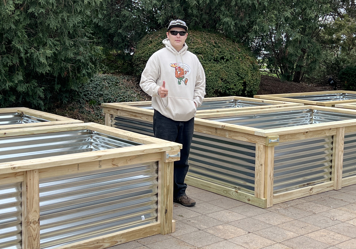 Stiner standing between the raised garden beds